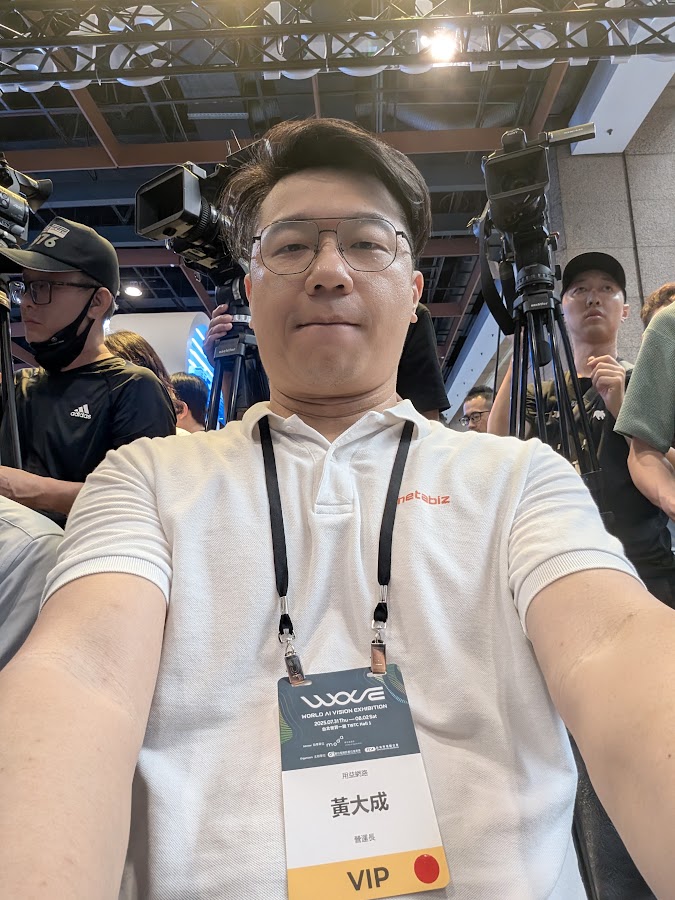 BLAKE 穿著 metabiz 上衣，配戴活動識別證的現場自拍