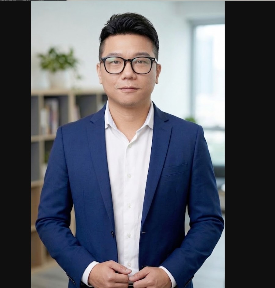 William Blake Huang 黃大成穿著藍色西裝，站在辦公空間中